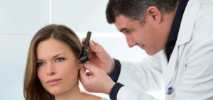 Un médecin examine l'oreille avec l'otoscope